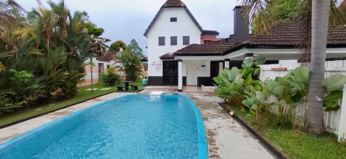 ein Haus mit einem Pool vor einem Haus in der Unterkunft A'Famosa Private Pool Villa in Kampong Alor Gajah