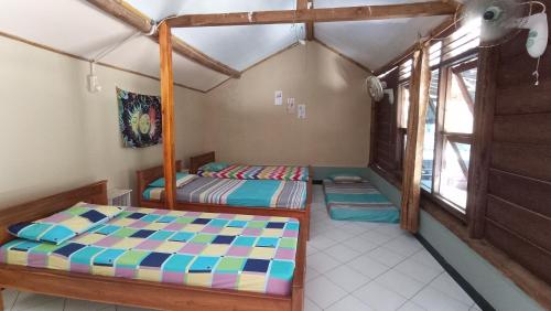 a bedroom with two beds and a window at Harry's Ocean House Watukarung Homestay in Kalak