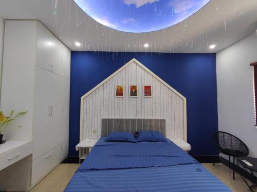 - une chambre avec un grand lit et un mur bleu dans l'établissement Balaha, à Dong Hoi