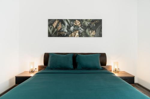 een slaapkamer met een groen bed en 2 nachtkastjes bij Skylark - Miami Studio with Terrace & Mountain View in Braşov