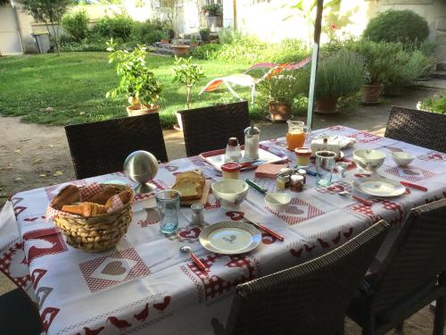 una mesa con un mantel con comida. en Les Tamayas, en Noizay
