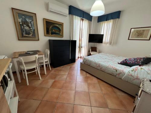 a bedroom with a bed and a table and a desk at L’ESSENZIALE in Pula