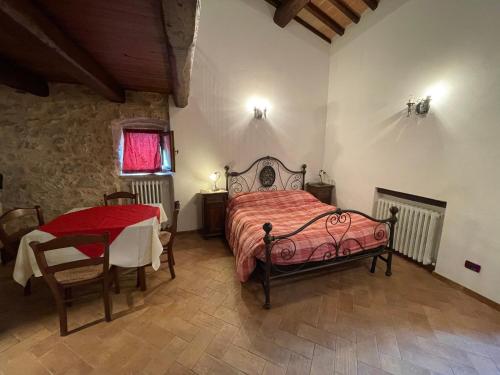 Un dormitorio con una cama y una mesa. en Agriturismo Antico Castagno, en Montebibico