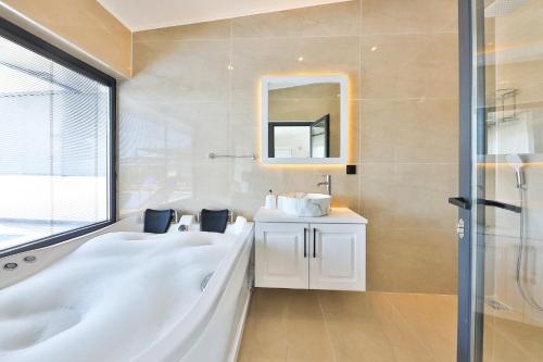 y baño con bañera, lavabo y espejo. en Villa Summery en Kalkan