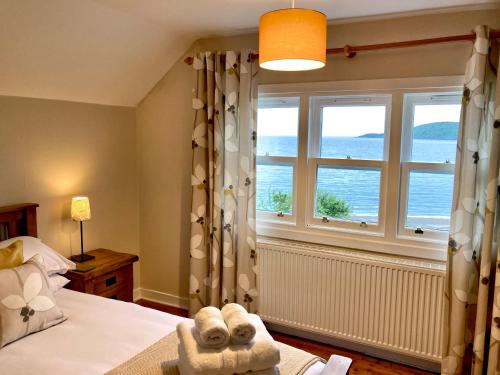 a bedroom with a bed with a teddy bear on it at Craigneuk near Oban, stunning home with sea views in Oban