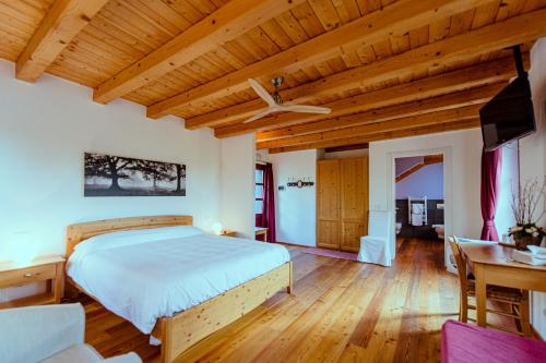 a bedroom with a bed and a wooden ceiling at Agriturismo Ronchi Rò in Lonzano