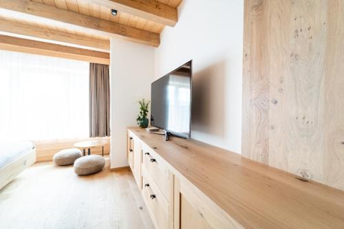 a living room with a flat screen tv on a wooden wall at Farma František in Stachy