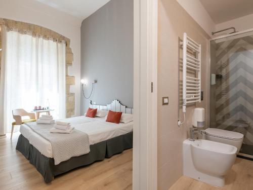 1 dormitorio con cama, aseo y lavamanos en Orma Design Rooms - Historic centre, en Cagliari