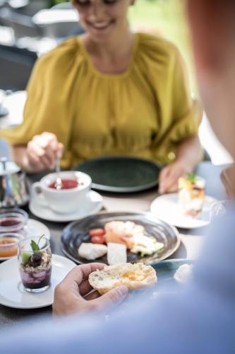 a woman sitting at a table with plates of food at Aparthotel Gamz in Sesto