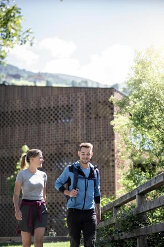 a man and a woman walking down a trail at Aparthotel Gamz in Sesto