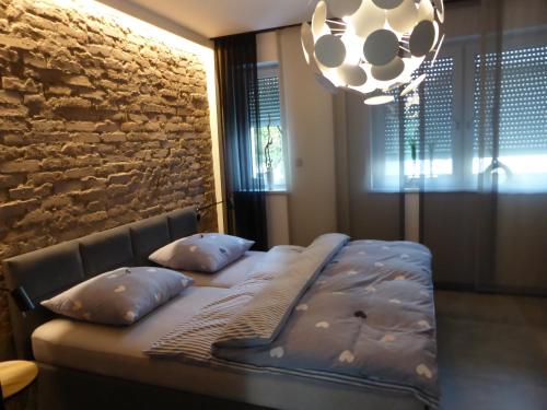 łóżko z poduszkami w pokoju z kamienną ścianą w obiekcie Apartament Premium Moszna w Mosznej
