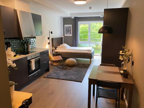 ein Wohnzimmer mit einer Küche und ein Zimmer mit einem Sofa in der Unterkunft Magnolia House Norrviken in Sollentuna