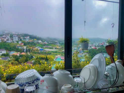 a table with plates and cups and a view of a city at Hoshi DaLat House in Da Lat