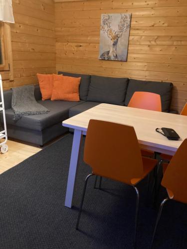 a living room with a table and a couch at Asplunda Gård, Kolmården stuga nr 2 in Kolmården