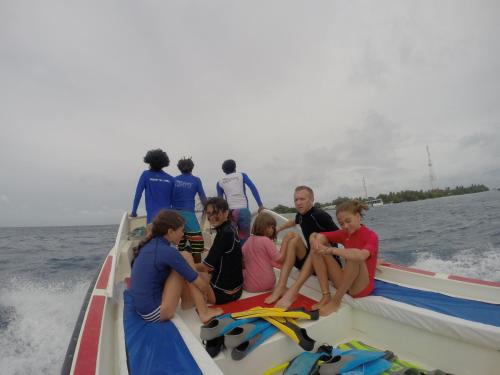 a group of people sitting on a boat in the water at Rasdhoo Coralville in Rasdu