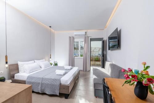 a bedroom with a bed and a couch and a tv at Sea Sun Apartment in Amoudara Herakliou