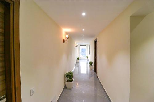 a hallway with potted plants and a cross on the wall at FabHotel Prime K9 Regency in Jalandhar