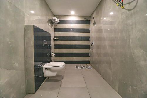 a bathroom with a toilet and a striped wall at FabHotel Prime K9 Regency in Jalandhar