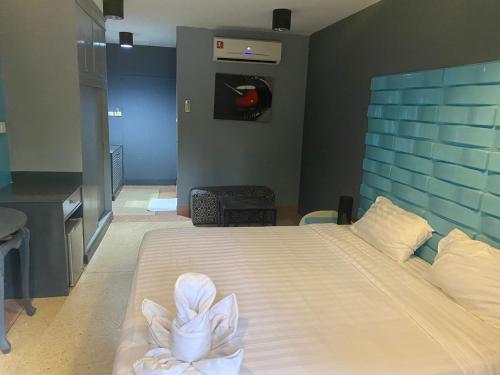 a bedroom with a large bed with white sheets at Momento Resort in Pattaya South