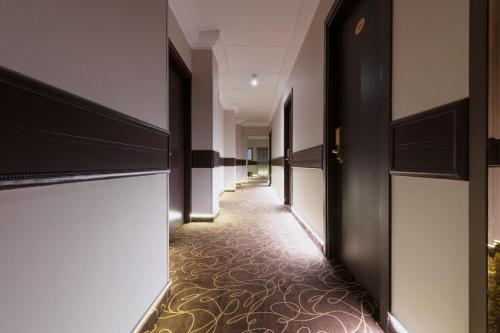 a hallway of a hotel with black doors and a carpet at Mokinba Hotels Montebianco in Milan