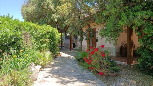 una casa con un jardín con flores y árboles en Agriturismo Le Vedute, en Bisceglie