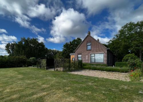 a brick house with a grassy yard at Studio49 in Ouddorp