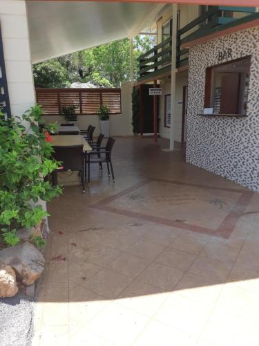 a patio with a table and chairs in a building at Whitsunday Sands Resort in Bowen