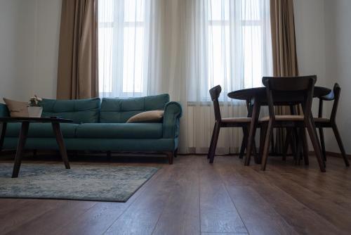 a living room with a green couch and a table at Spring Rustik in Čačak