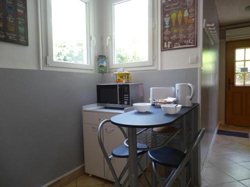 a small kitchen with a table and a microwave at L'Escapade in Eu
