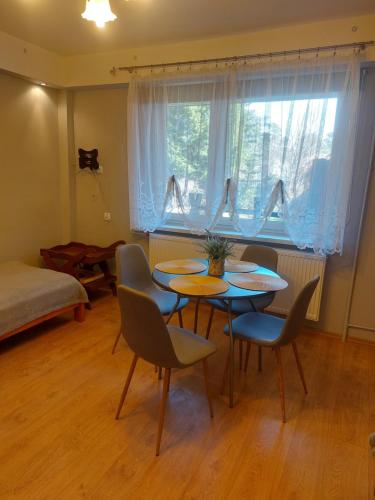 ムロンゴヴォにあるZakątek na Krzywejのテーブルと椅子、窓が備わる客室です。