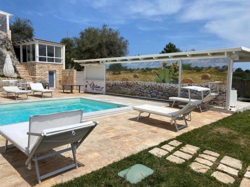 a swimming pool with two lounge chairs and a patio at La Terrazza Sulla Rupe Relais in Ostuni