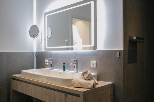 a bathroom with a sink and a mirror at Forellenhof Appartements & Grossmutters Bungalow in Leutasch