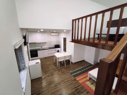 ein Wohnzimmer mit einer Treppe und eine Küche in der Unterkunft Quinta do Gestal - Soutelo in Vila Verde