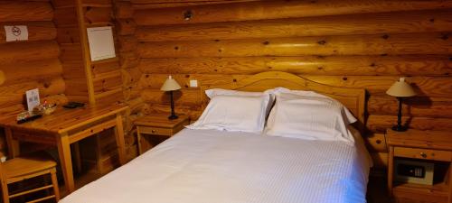 a bedroom with a bed in a log cabin at Hôtel Résidence Le Pin Sylvestre Amnéville in Amnéville