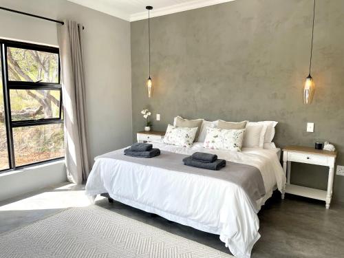 a bedroom with a large bed with two towels on it at Summerplace Game Reserve in Vaalwater
