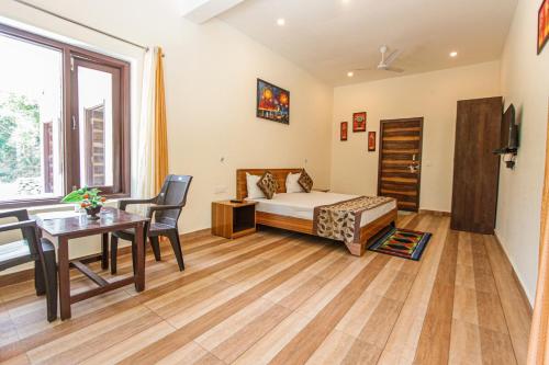 a bedroom with a bed and a desk and a table at Bajoon homestay in Bhīm Tāl