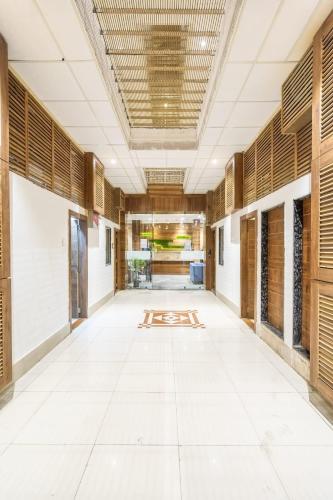an empty hallway of an office building with wooden windows at Hotel Bhabha in Rajkot