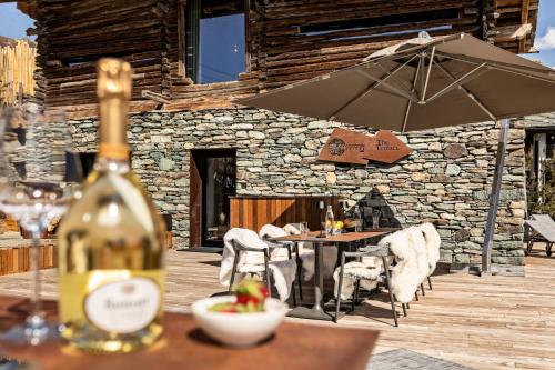 a bottle of wine on a table with an umbrella at Cocoon Deluxe - Luxury Chalet in Chamois