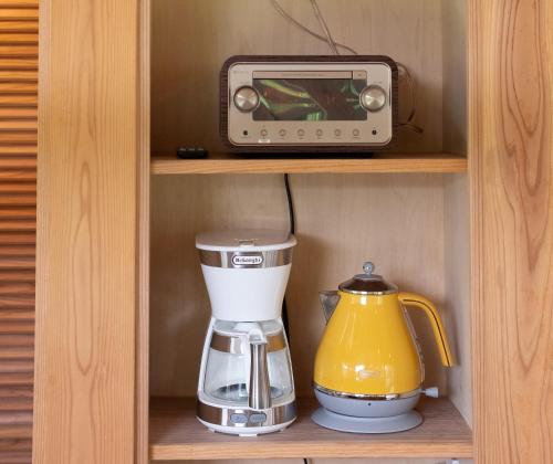 a coffee maker and a toaster sitting on a shelf at 泊まれるアートミュージアム 琉球ヴィラ in Tatsugo