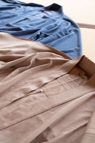 a pile of clothes sitting on top of a bed at 泊まれるアートミュージアム 琉球ヴィラ in Tatsugo