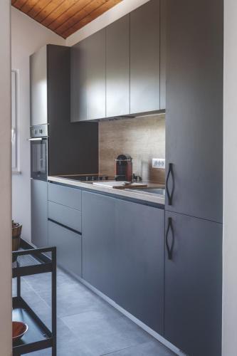 a kitchen with gray cabinets and a stove top oven at Center apartment Golden Ray in Bol