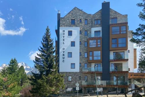 a building with a clock on the side of it at Apartmán 405 Hotel OVRUČ in Štrbské Pleso