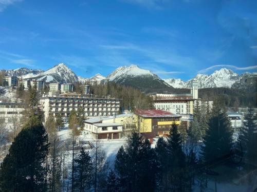 a city with snow covered mountains in the background at Apartmán 405 Hotel OVRUČ in Štrbské Pleso