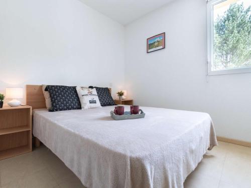 une chambre avec un grand lit blanc avec une fenêtre dans l'établissement Appartement cosy 7 pers à Saint-Lary avec balcon, parking et navette gratuite - FR-1-296-332, à Saint-Lary-Soulan