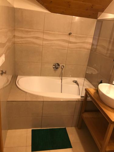a bathroom with a tub and a sink at ubytování u Smolíků in Třeboň