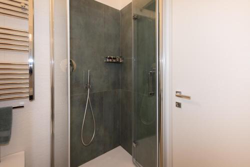 a bathroom with a shower with a glass door at LOFT LUNGOMARE vista MARE e MONTI in Àrbatax