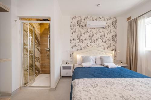a bedroom with a bed and a walk in shower at Vela Blu Boutique Suites in Il-Gżira