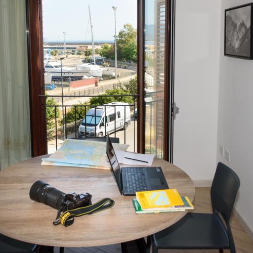 a table with a laptop and a camera on it at LOFT LUNGOMARE vista MARE e MONTI in Àrbatax