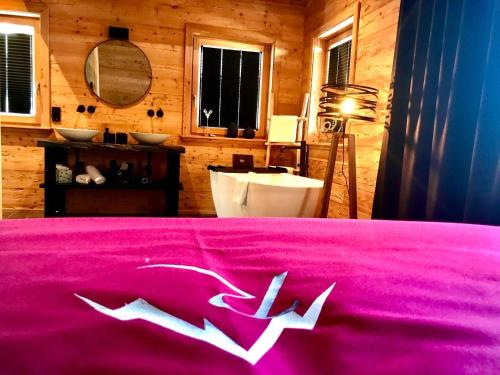 ein Schlafzimmer mit einer rosa Tagesdecke mit weißen Pfeilen darauf in der Unterkunft Mountain Chalet R in Berwang