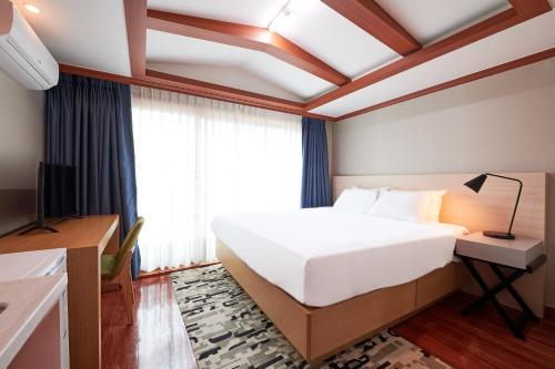 a bedroom with a large white bed and a window at Sokcho Good Morning Hotel and Resort in Sokcho